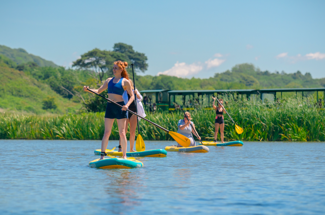 Four women on individual stand up paddle boards
